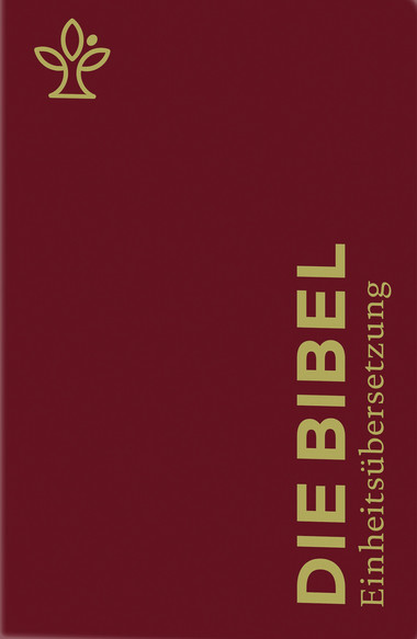 Ein dunkelrotes Buch mit goldener Prägung . Auf dem Buchdeckel steht in großen, senkrechten Buchstaben der Titel 'DIE BIBEL', darunter in kleinerer Schrift 'Einheitsübersetzung'. In der linken oberen Ecke befindet sich ein stilisiertes, goldfarbenes Pflanzensymbol
